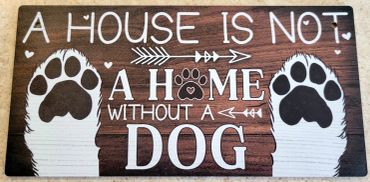 Wooden sign saying a house is not a home without a dog with dog paw prints.