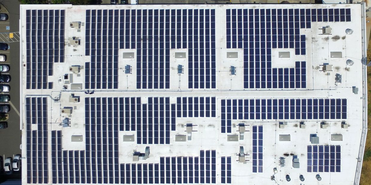 Ariel view of a commercial building with solar panels on roof.