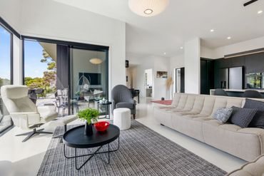 Modern open living space with neutral tones and large windows.