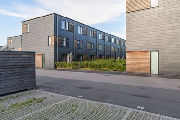 Modern residential buildings with parking spaces in front.