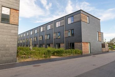 Modern townhouse complex with gray and wooden panel exteriors.