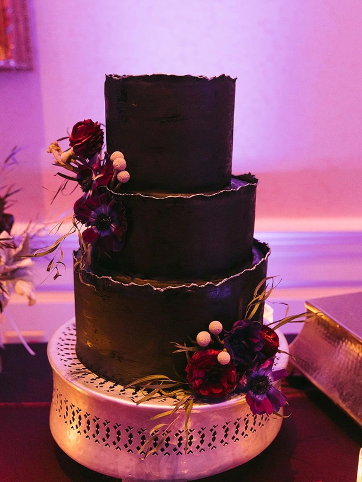 black wedding cake with purple up lighting at an asheville wedding at Biltmore Estate