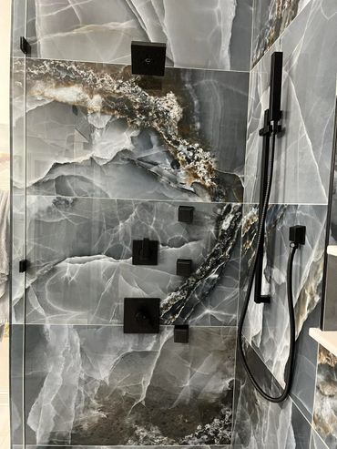 Modern shower with black fixtures and elegant blue-gray marble tiles.