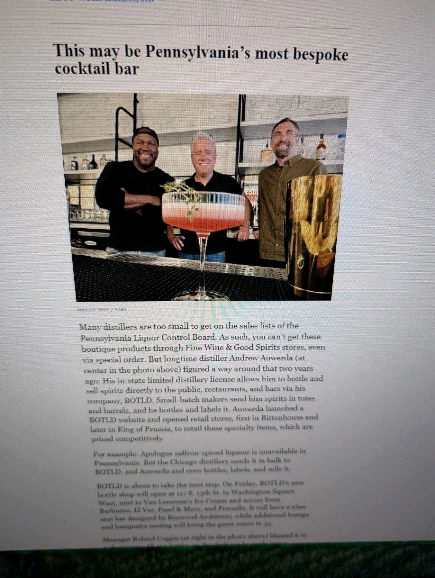 Three men smile behind a bespoke cocktail in a Pennsylvania bar.
