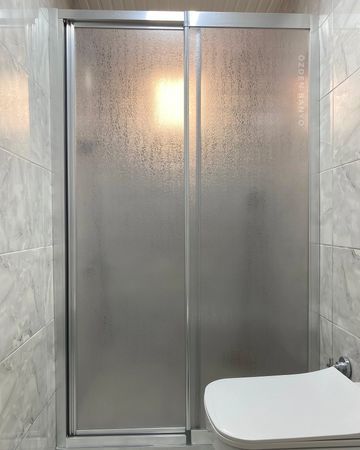 Frosted glass shower doors in a modern bathroom.