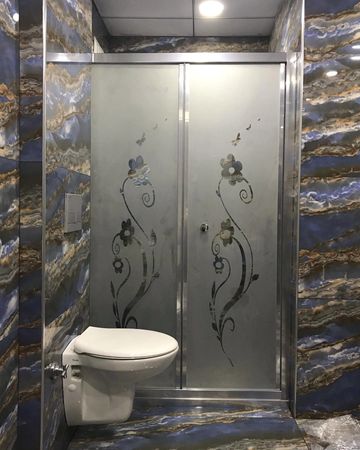 Modern bathroom with floral etched glass shower doors and a wall-mounted toilet.