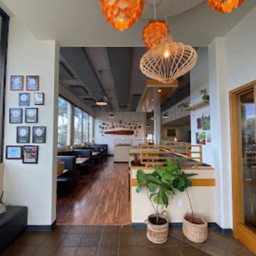 Cozy modern cafe interior with wooden floors and unique pendant lights.