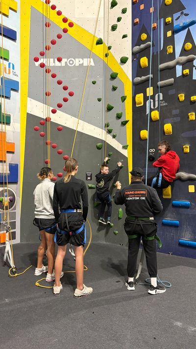 People climbing walls at an indoor climbing gym.