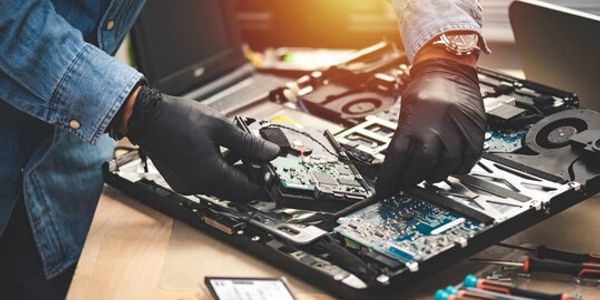 Technician repairing a computer's internal hardware components.
