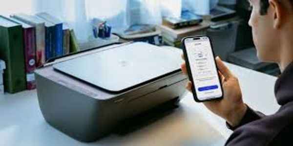 Person using smartphone to connect with printer on desk.