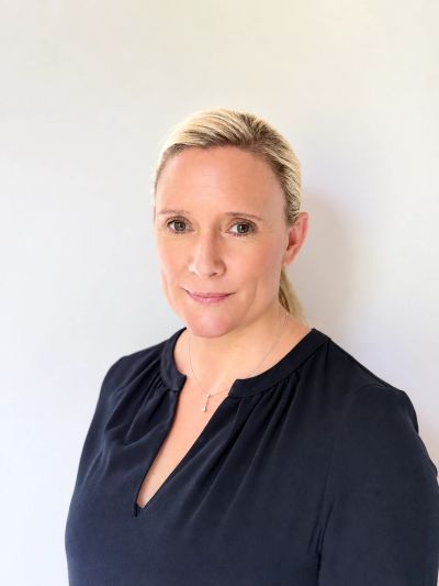 Professional photo of a confident woman in a black blouse against white background.