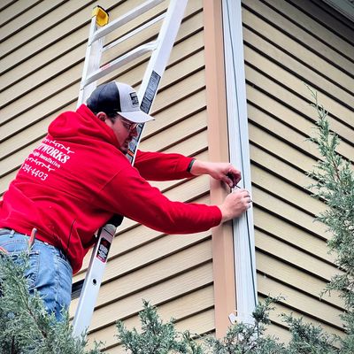 installing Christmas lights on a ladder