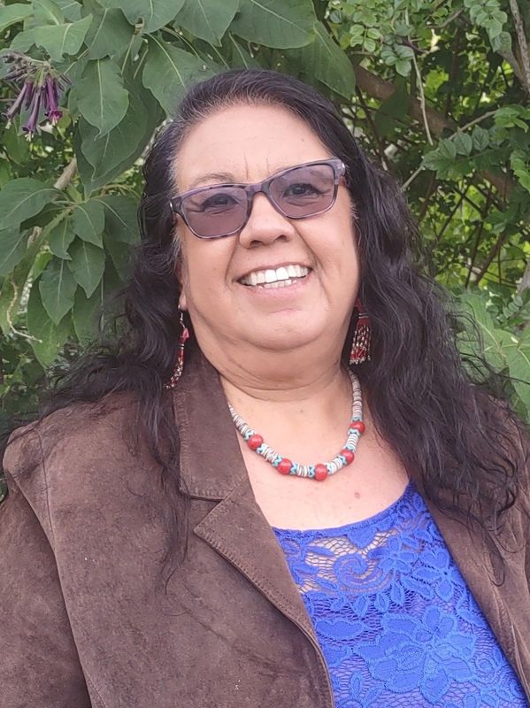 A woman in sunglasses smiles warmly