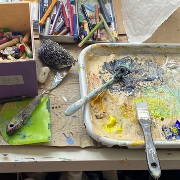 Painting materials in the studio to include spatulas, watercolour pencils, pastels, marking  tools