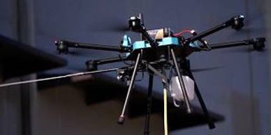 A large drone with multiple rotors hovers indoors.