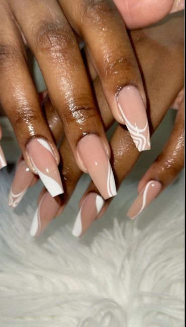 A woman lifting her hand to show off her stylish nail design.