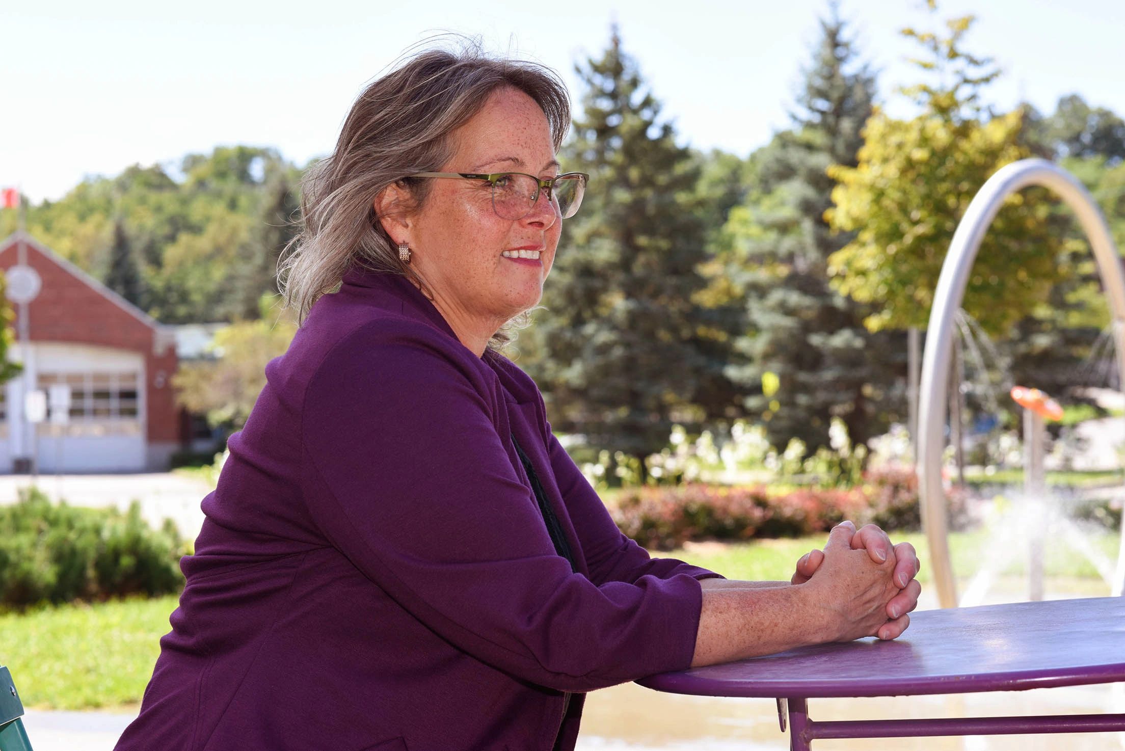 Vikki in purple jacket sitting outside at a table.