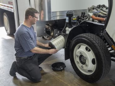 Mechanic replacing a truck air filter.