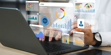 Person analyzing digital data charts on a laptop screen in a modern workspace.