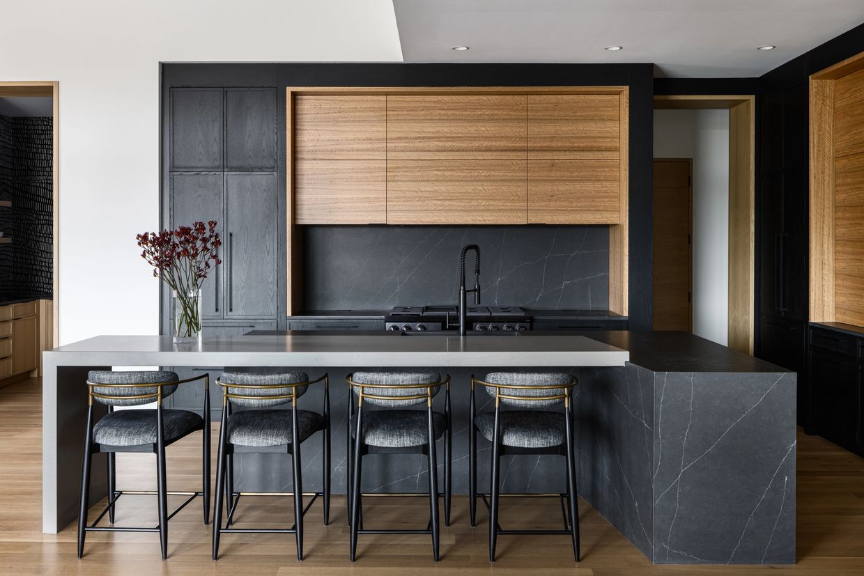Custom modern kitchen featuring a striking contrast of black and natural wood cabinetry.
