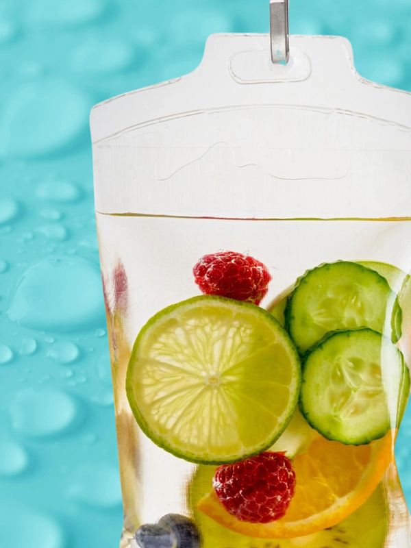 A clear pouch filled with water and fresh fruit slices against a blue background.