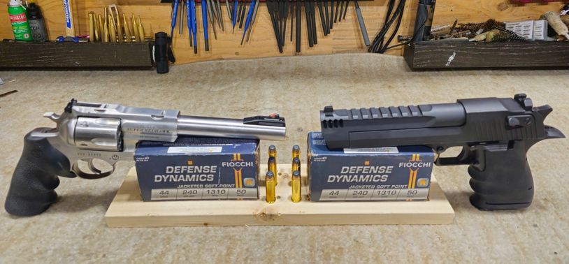 Two handguns displayed with ammunition boxes and bullets.