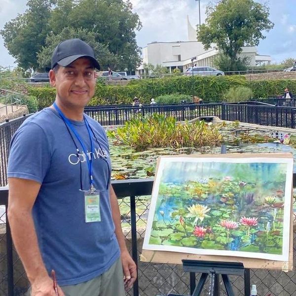 Oh man wearing blue t shirt and looking ahead for a showing painting