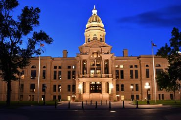 Illuminated historic government building at twilight.