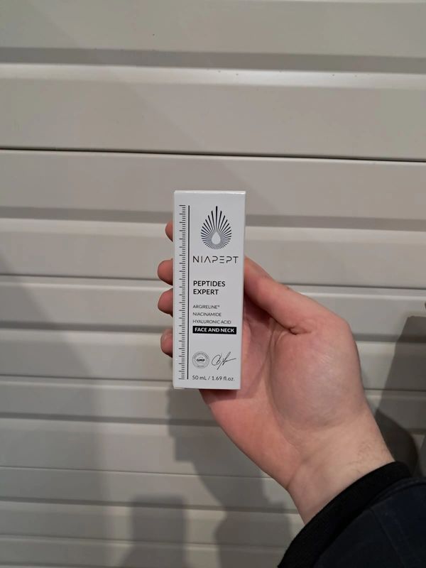 Hand holding Niapept Peptides Expert face and neck serum.