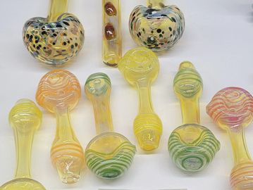 Colorful glass pipes with unique patterns displayed on a white surface.