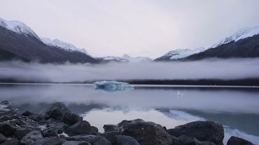 Mountains and fog reflect on a lake in Chugach National Forest in Alaska