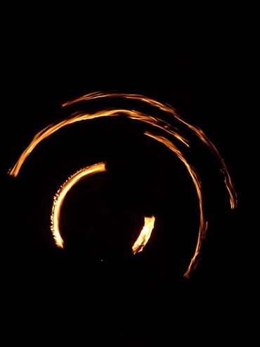 Swirls of light from a fire poi dancer in Costa Rica burst through a dark night