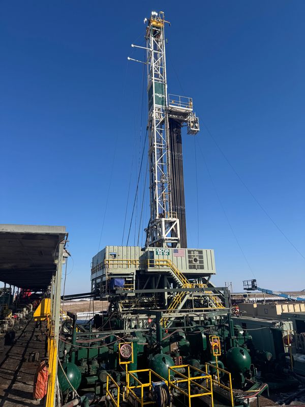Oil drilling rig against a clear blue sky on a sunny day.