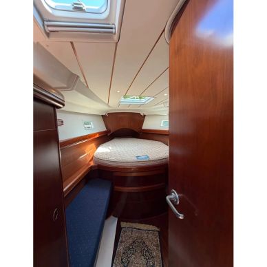 Interior view of a cozy boat cabin with a bed and a skylight.