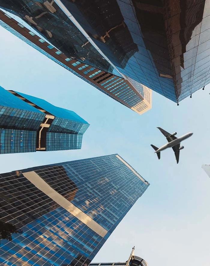 Airplane flying over skyscrapers.
