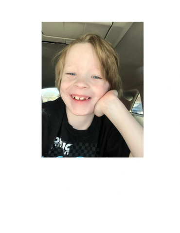 Young boy smiling and posing for the camera.