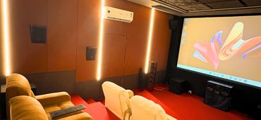 Cozy home theater with plush seating and a large screen.