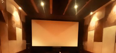 Cozy home theater with plush seating and a large screen.