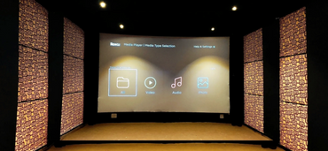 Home theater setup with Roku media player interface on a large screen.