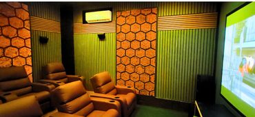 Cozy home theater with recliner seats and hexagonal wall panels.