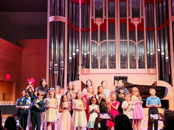 Spring Recital Picture Holding Thropheys on Stage.