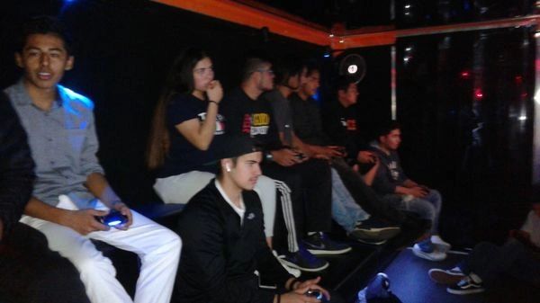 Group of young people playing video games in a dark room.