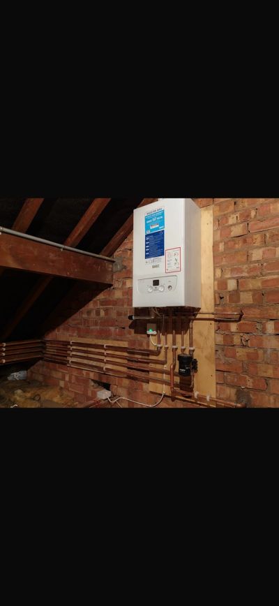 Wall-mounted boiler with copper pipes in an attic.