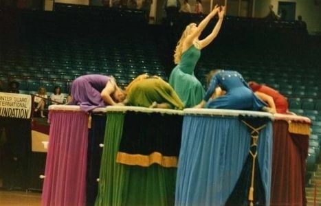 Dancers in colorful dresses performing on a raised platform.