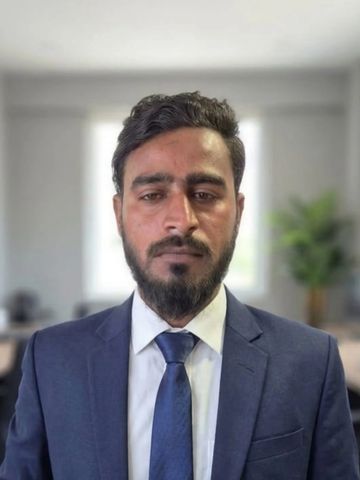 Man in a blue suit and tie posing for a portrait.