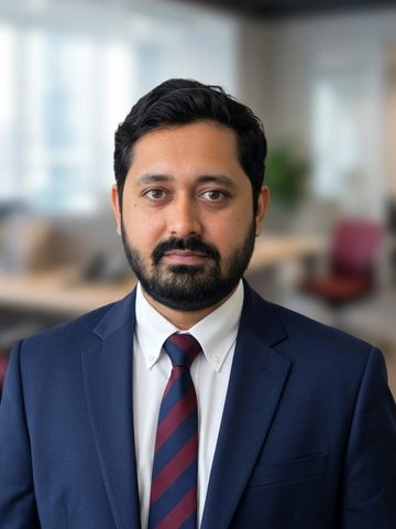 Professional man in suit and tie posing in office.