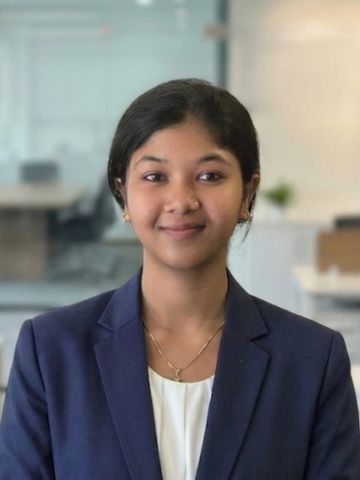 Young professional woman smiling confidently in a modern office.