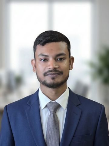 Young man in a blue suit and tie posing confidently indoors.