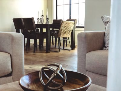 Modern dining area with wooden table and mixed chairs.