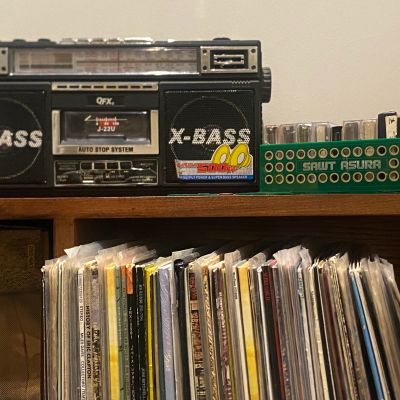 Old cassette player with vinyl records and batteries.